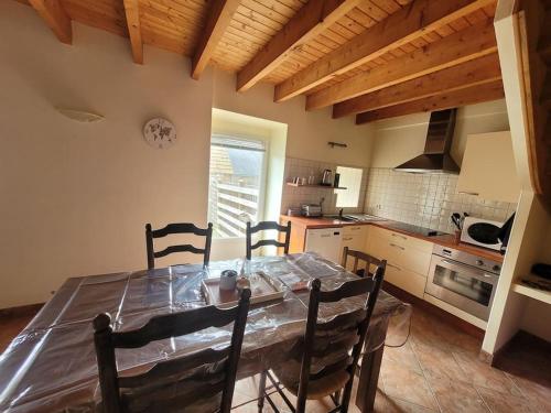 Coeur de Granit في تريغاستيل: مطبخ مع طاولة طعام وكراسي في غرفة