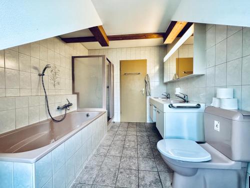La salle de bains est pourvue d'une baignoire, de toilettes et d'un lavabo. dans l'établissement Monteurzimmer ZIMMERzuVERMIETEN in Flumenthal Solothurn, à Attiswil