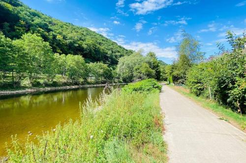 a path next to a river next to a forest at L’Echo de l’Ourthe - Tilff (Liège) in Tilff