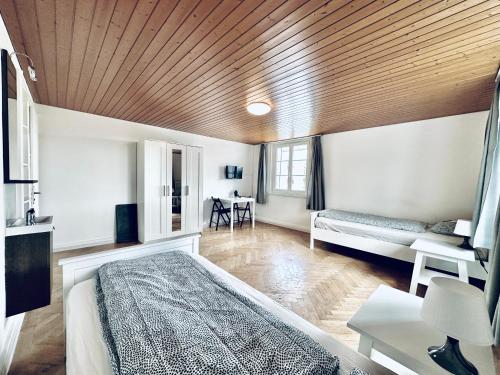 Un dormitorio con una cama y un techo de madera. en Monteurzimmer - Worker's accommodation - ZIMMERzuVERMIETEN in Flumenthal Solothurn, en Flumenthal