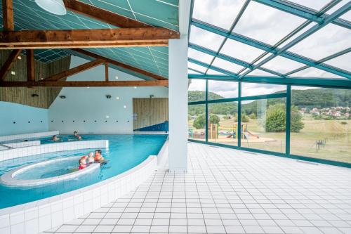 basen z ludźmi w wodzie w obiekcie Camping Les Vosges du Nord w mieście Oberbronn