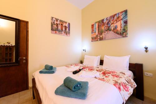 a bedroom with a bed with towels on it at My Place in the Colony in Zikhron Ya‘aqov