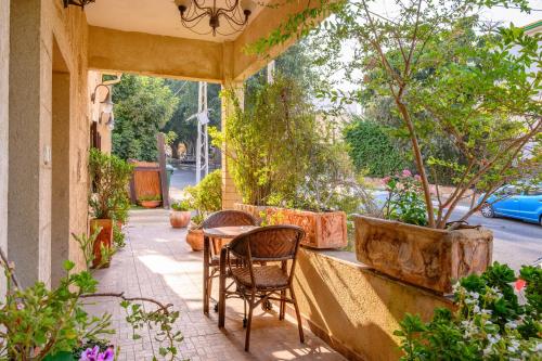 a table and chairs on a patio with plants at My Place in the Colony in Zikhron Ya‘aqov