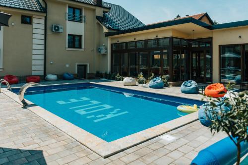 uma piscina em frente a uma casa em HOTEL Villa Cvijanović - WELLNESS-SPA em Palić