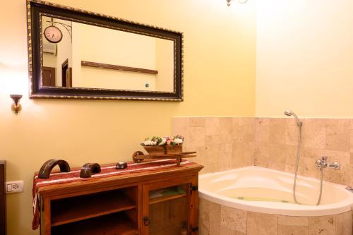 een badkamer met een bad en een spiegel bij המקום שלי במושבה - My Place in the Colony in Zikhron Ya‘aqov