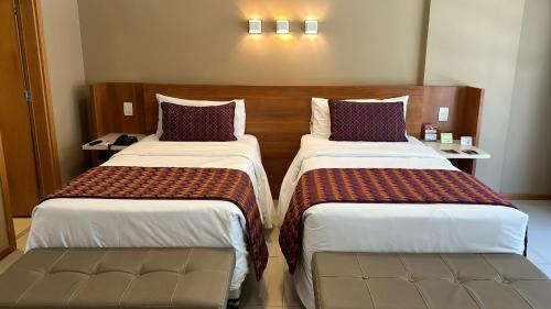 a hotel room with two beds in a room at Jade Hotel Brasília in Brasilia