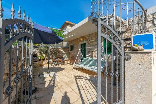 a gate to a house with an umbrella and a patio at House Stipan in Vinišće