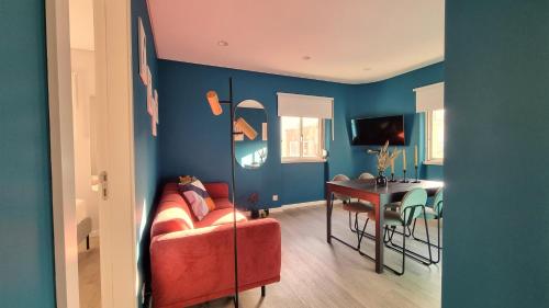 a living room with a red couch and a table at Afonso Galo Guest Apartments IV in Almada