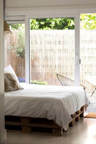 een slaapkamer met een bed voor een raam bij Slapen bij Zoet & Zilt in Middelburg