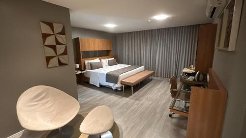 a hotel room with a bed and two chairs at Jade Hotel Brasília in Brasilia