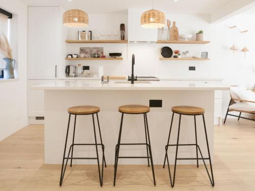 a kitchen with two bar stools at a kitchen island at Pass the Keys - Beautiful designer Maisonette with Garden and BBQ in London