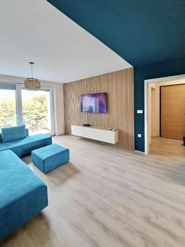 ein Wohnzimmer mit blauen Möbeln und einem Flachbild-TV in der Unterkunft Elegant 1BR Dream Apartment in Central Ohrid in Ohrid