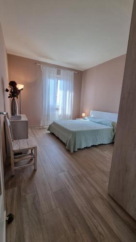 een slaapkamer met een bed, een stoel en een raam bij Agriturismo La Corte in Pistoia