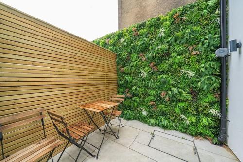 a green wall with two chairs and a table at The Solo Haven 20 Min to Central in London