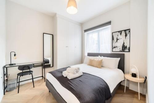 Un dormitorio con una cama con una toalla. en The Solo Haven 20 Min to Central, en Londres