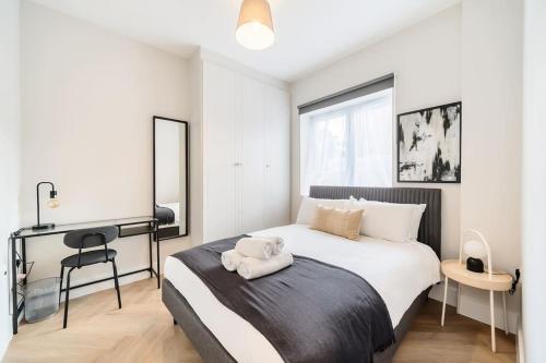 a bedroom with a bed with a towel on it at The Solo Haven 20 Min to Central in London