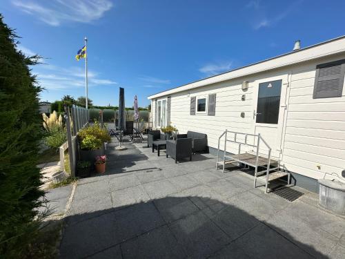 a patio next to a white trailer with benches at Effe Niks in Buren