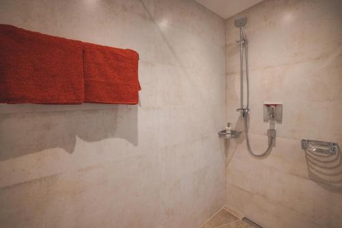 a bathroom with a shower with red towels at Appartements Bucher in Brixen im Thale