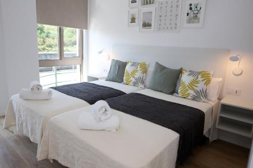 um quarto com 2 camas e toalhas em VUT PEDRO LUXURY em Padrón