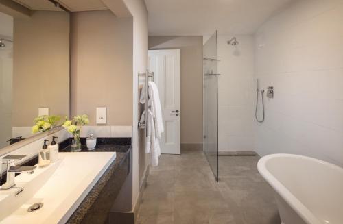 uma casa de banho com 2 lavatórios e um chuveiro em Le Quartier Francais em Franschhoek