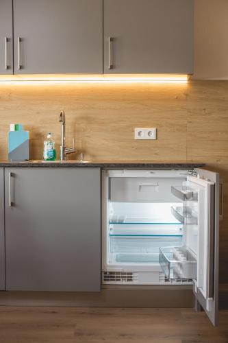 an empty refrigerator with its door open in a kitchen at Appartements Bucher in Brixen im Thale