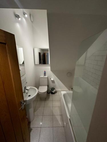 a bathroom with a toilet and a sink and a tub at Calverley House Apartments in Bishops Stortford