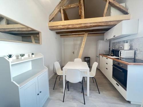 Saint-Ay的住宿－La Brise Maritime，厨房配有白色的桌子和白色的椅子