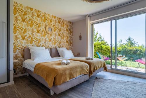 a bedroom with a bed and a large window at Le Nichoir de la Colline - Parking & Wifi in Obernai