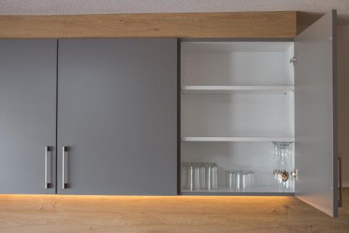 a cupboard with glass doors in a room at Appartements Bucher in Brixen im Thale