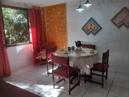 jadalnia ze stołem i krzesłami oraz oknem w obiekcie Casa condomínio paz w mieście Petrópolis