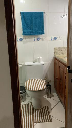 a bathroom with a toilet and a blue towel at Flat lindo paraty in Paraty