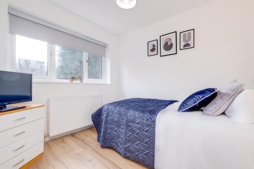a white bedroom with a bed and a flat screen tv at Alpha House by Night Stay: Contractors Sleeps 8 in Birmingham