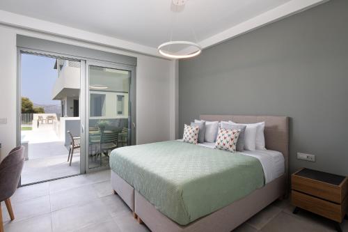 a bedroom with a bed and a balcony at Heliades Residence in Kounoupidhianá