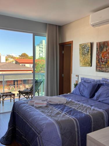 a bedroom with a bed and a large window at Suite Montparnasse in Lagoa Santa