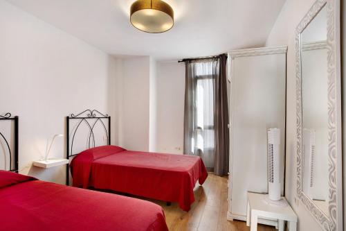 - une chambre avec 2 lits rouges et une fenêtre dans l'établissement Apartamento Playa Morro Jable 1a, à Morro del Jable