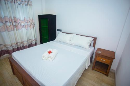 a bedroom with a bed with two slippers on it at DR. Place in Hikkaduwa