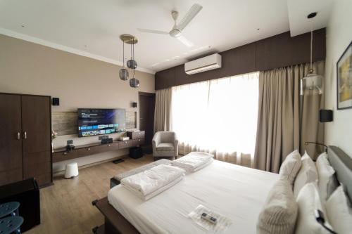 a hotel room with a bed and a tv at Central Bed & Breakfast in Kolkata