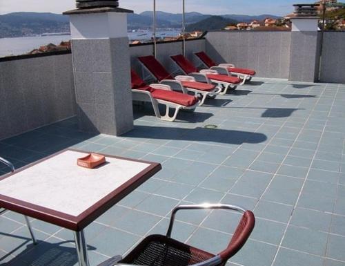 a row of chairs and tables on a balcony at Hotel Xeito in Combarro