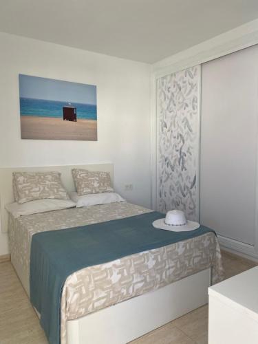 biała sypialnia z łóżkiem z niebieskim kocem w obiekcie MiVida w mieście San Bartolomé