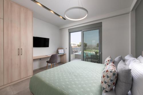 a bedroom with a bed and a desk and a television at Heliades Residence in Kounoupidhianá