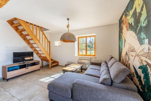 a living room with a couch and a tv at Les Sarments du Beaujolais, campagne proche Lyon in Sarcey