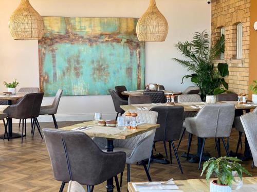 a restaurant with tables and chairs and a painting on the wall at The Spa Hotel in Saltburn-by-the-Sea