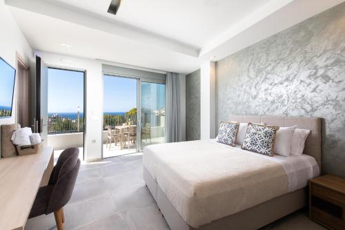 a bedroom with a bed and a large window at Heliades Residence in Kounoupidhianá