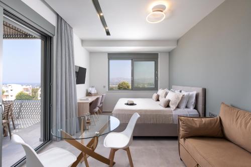 a bedroom with a bed and a couch and a glass table at Heliades Residence in Kounoupidhianá