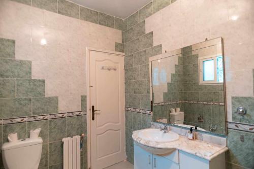 La salle de bains est pourvue d'un lavabo, d'un miroir et de toilettes. dans l'établissement sejour chez Marwa, à Sidi Bou Saïd