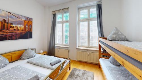 a bedroom with two beds and two windows at zentrales Loft mitten in Leipzig in Leipzig