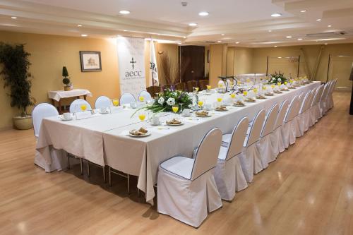 a long table with white tables and chairs in a room at Hotel Gran Via in Logroño