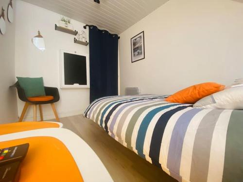 1 dormitorio con 1 cama y 1 silla en Chez Zivou au pied de la plage, en Mers-les-Bains