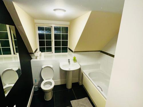 a bathroom with a toilet and a sink and a tub at Stunning 5-Bed House in Peterborough host 15 g in Peterborough