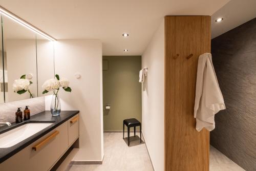 a bathroom with a sink and a mirror at Hotel Chesa Rosatsch - Home of Food in Celerina